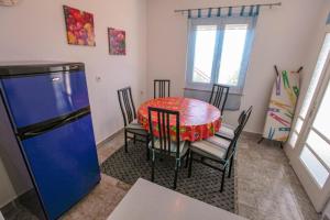 a kitchen with a table and chairs and a blue refrigerator at Apartments Gaspar in Podaca