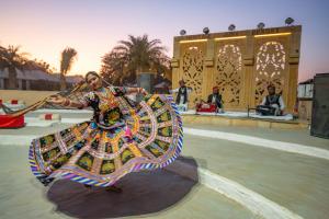 a woman in a colorful dress playing a drum at Heritage Juma Resort with swimming pool in Jaisalmer +76 photos