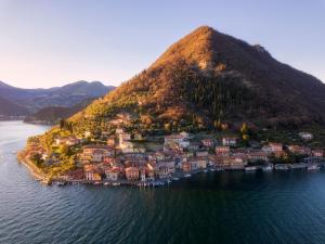 an island in the water with houses on a hill at Il Fico Lake Iseo b&b in Iseo