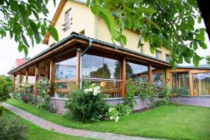 a building with a lot of windows and plants at Mamos virtuve in Avižieniai