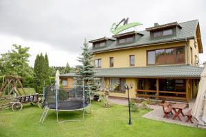 a house with a playground in the yard at Mamos virtuve in Avižieniai