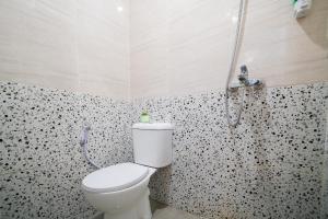 a bathroom with a toilet and a shower at Behomy Urban Point Karawang in Karawang