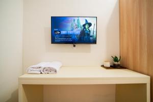 a flat screen tv hanging on a wall in a room at Behomy Urban Point Karawang in Karawang