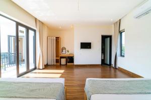 a living room with two beds and a television at Villa Layna's home in An Bàn (2)