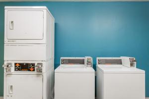 Tres refrigeradores están alineados contra una pared azul en Days Inn by Wyndham Vernal en Vernal