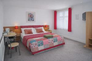 a bedroom with a bed and a table and a desk at The Fairhaven Hotel in Nottingham