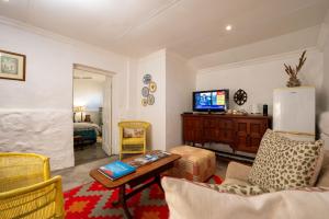 a living room with a couch and a tv at Kuilfontein Stable Cottages in Colesberg