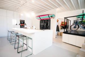 a kitchen with white cabinets and a counter with stools at Surf Sea and Sun in Biarritz
