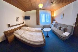 a bedroom with a large bed and a couch at BLACKCOMs Erika in Goslar