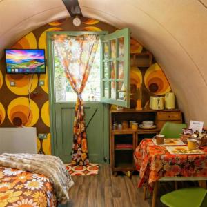 a room with a bed and a table and a window at Caplor Glamping & Lodges in Hereford +64 photos