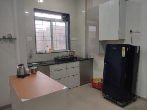 a kitchen with a black refrigerator and a window at Apartment in Igatpuri! in Igatpuri