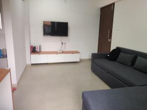 a living room with a couch and a flat screen tv at Apartment in Igatpuri! in Igatpuri