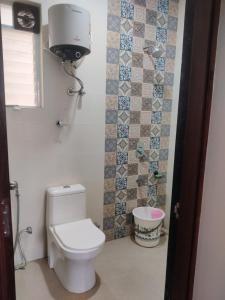 a bathroom with a white toilet and a sink at Apartment in Igatpuri! in Igatpuri