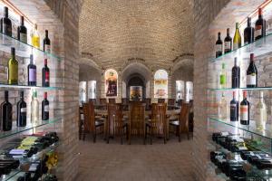 a restaurant with a bar with bottles of wine at Hotel Club Tisza in Lakitelek