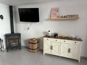 a room with a fireplace and a television on the wall at La Marquesa - CA L'ONA in Poblenou del Delta
