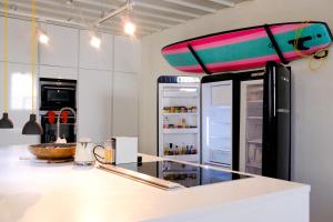 a kitchen with a refrigerator with a surfboard on top at Surf Sea and Sun in Biarritz
