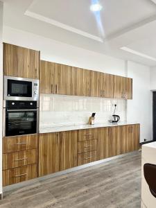 a kitchen with wooden cabinets and a microwave at Lux-Home Enugu in Enugu