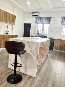 a kitchen with a counter and a black stool at Lux-Home Enugu in Enugu +12 photos