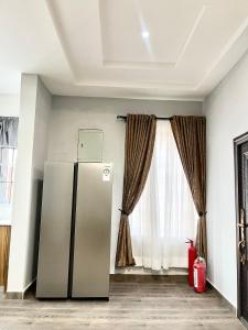 a refrigerator in a room with a window at Lux-Home Enugu in Enugu