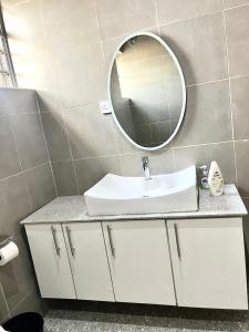 a bathroom with a sink and a mirror at Lux-Home Enugu in Enugu