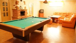 a living room with a pool table and a fireplace at Suraučių Svečių Namai in Aukštadvaris