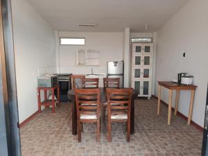 a kitchen with wooden chairs and a table and a counter at Casuarinas Del Mar Chalet de 2 habitaciones in Canoas de Punta Sal
