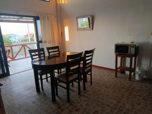 a dining room with a table and chairs and a microwave at Casuarinas Del Mar Chalet de 2 habitaciones in Canoas de Punta Sal +20 photos