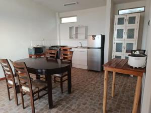 a kitchen with a table and chairs and a refrigerator at Casuarinas Del Mar Chalet de 2 habitaciones in Canoas de Punta Sal