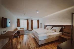 a hotel room with a bed and a desk at Burghotel Schlaining in Stadtschlaining