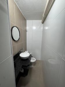a white bathroom with a sink and a toilet at Book a bed Jacumã in Conde