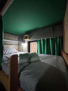 a bedroom with a green ceiling and two beds at Book a bed Jacumã in Conde