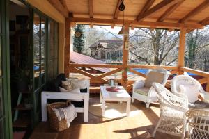 a screened porch with wicker chairs and a table at Guesthouse Silvani in Kruševac