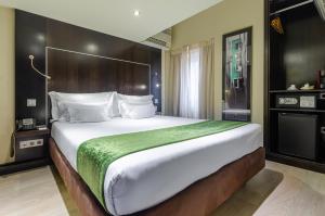 a bedroom with a large bed with a green blanket at behotelisboa in Lisbon