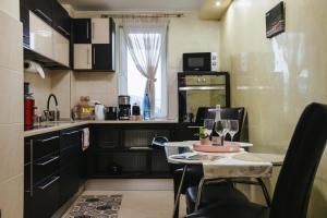 a small kitchen with a table with wine glasses on it at Downtown Cozy Retreat - parcare inclusa in Vatra Dornei