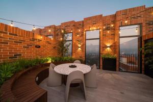 a patio with a table and chairs and a brick building at Studio Apartment Zona 10 near airport in Estación Pamplona