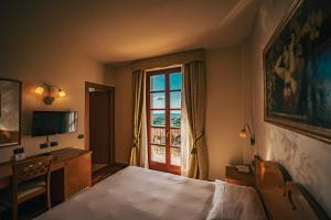 ein Hotelzimmer mit einem Bett und einem Fenster in der Unterkunft Hotel Camoretti in Almenno San Bartolomeo