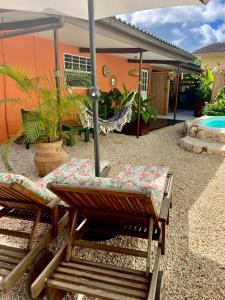 two chairs and an umbrella in front of a house at Tropical Appartment & Studio Curaçao in Dorp Sint Michiel