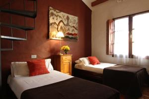 a room with two beds and a window at Hostería Lunahuana in Tafí del Valle