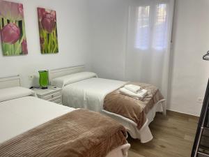 a white room with two beds and a window at El Olivar de la Solana in Castril +24 photos