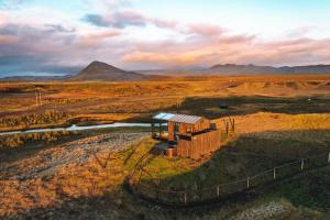 a small building in the middle of a field at Panorama Glass Lodge SOUTH in Hella