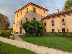 a large brick building with a tree in front of it at Bed & Breakfast Villa Buzzati in Belluno