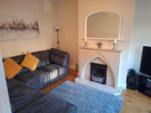 a living room with a couch and a fireplace at Rostrevor Beach House in Rostrevor