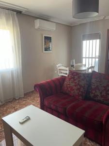 a living room with a red couch and a table at El Olivar de la Solana in Castril