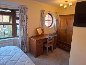 a bedroom with a desk and a mirror and a bed at Rostrevor Beach House in Rostrevor