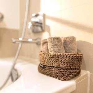 a basket of towels sitting on a counter in a bathroom at TrulySpace - Modernes Apartment am Rathausplatz, Terrasse, Fahrstuhl in Augsburg