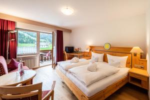 a hotel room with a large bed and a table at Hotel Birgsau in Oberstdorf