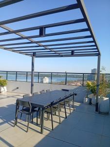 a table and chairs on a patio with a view of the ocean at LUXER VIVO Encarnacion in Encarnación