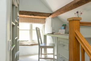 a kitchen with a desk and a chair in a room at Mill Cottage, Hanley Mill in Tenbury +2 photos
