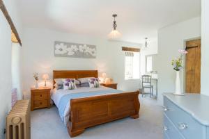a bedroom with a bed and a table and chairs at Mill Cottage, Hanley Mill in Tenbury