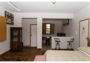 a bedroom with a bed and a kitchen with a table at Lofts do Largo in Tiradentes